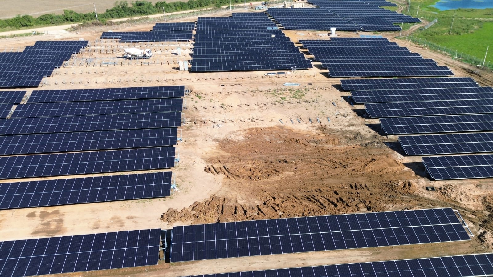 Vista aérea ampla da usina solar em construção no campo